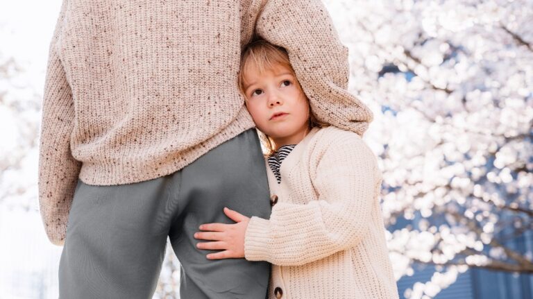 Little girl with sad face hugs her mother