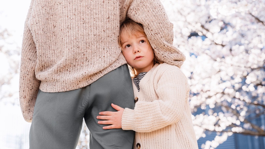 Little girl with sad face hugs her mother
