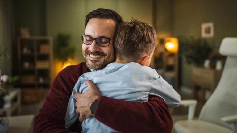 smiling father hugs his little son